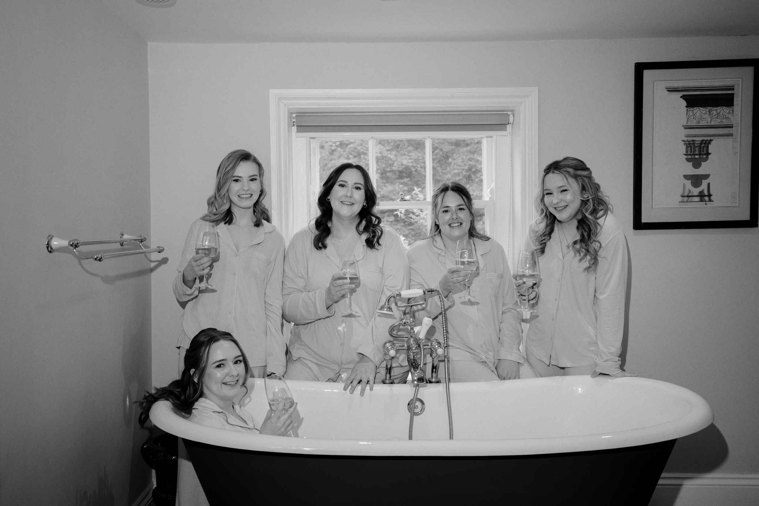 Bride in the bath surrounded by her bridesmaids before the wedding at Sledmere house in Driffield