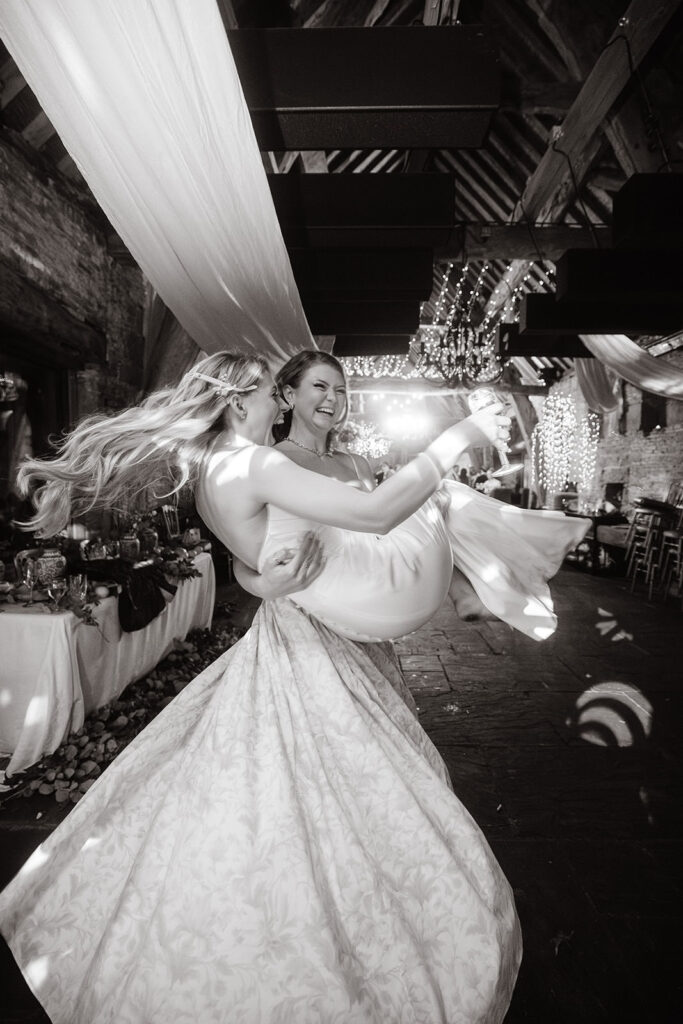 Bride picked up by guest and spinning on the dance floor. Photography at Barlow Woodseats Hall Wedding