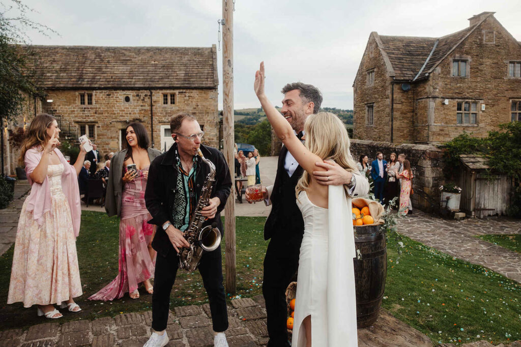 Bride and groom dancing to sax player at Barlow Woodseats Hall
