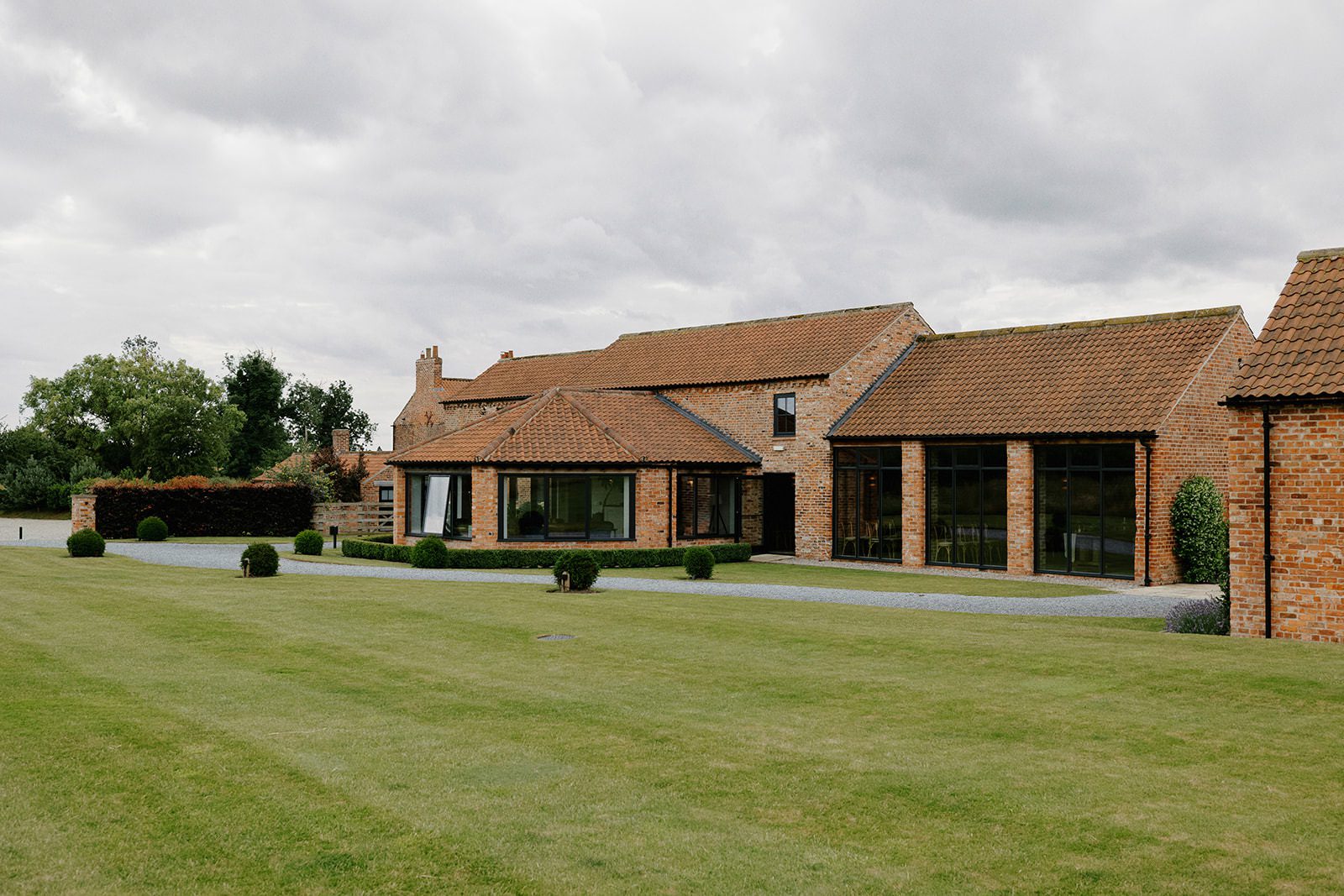 Red-brick barns and manicured lawn at Thirsk Lodge Barns wedding venue in North Yorkshire