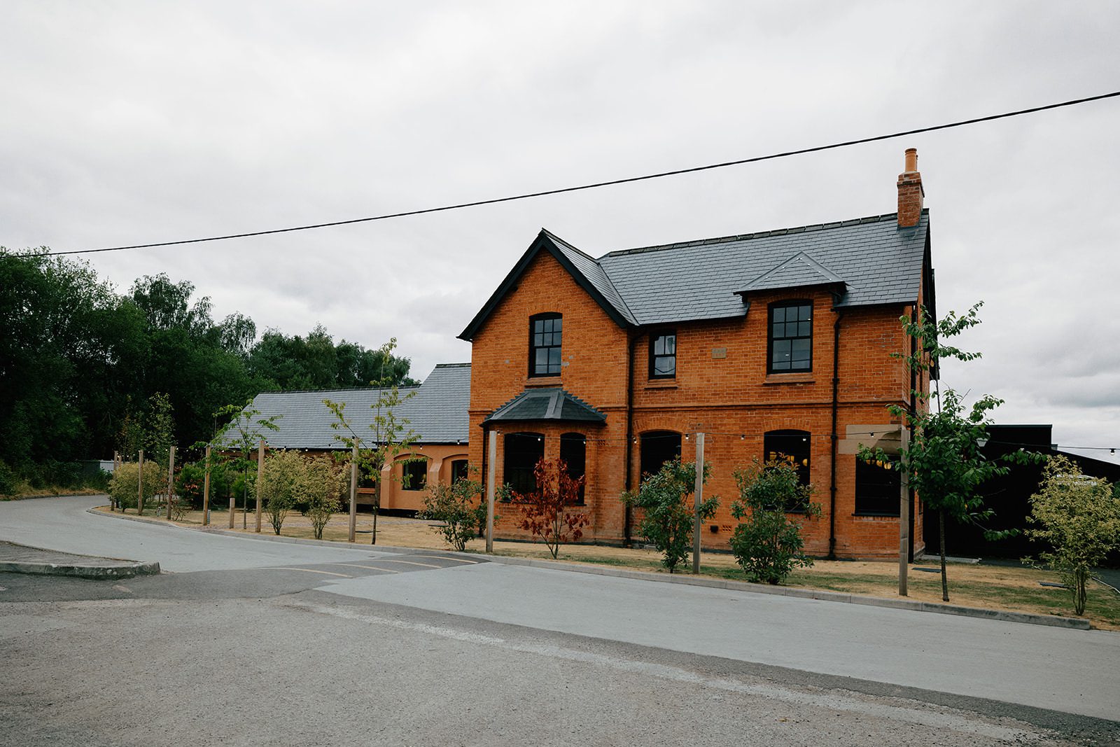 Red-brick farmhouse and slate roofs of Whistle Barns wedding venue in Derbyshire