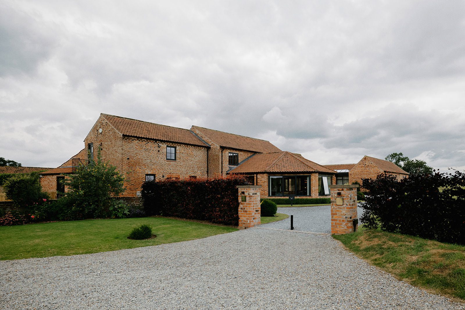 Gravel driveway and brick gate pillars leading to the converted barns at Thirsk Lodge Barns